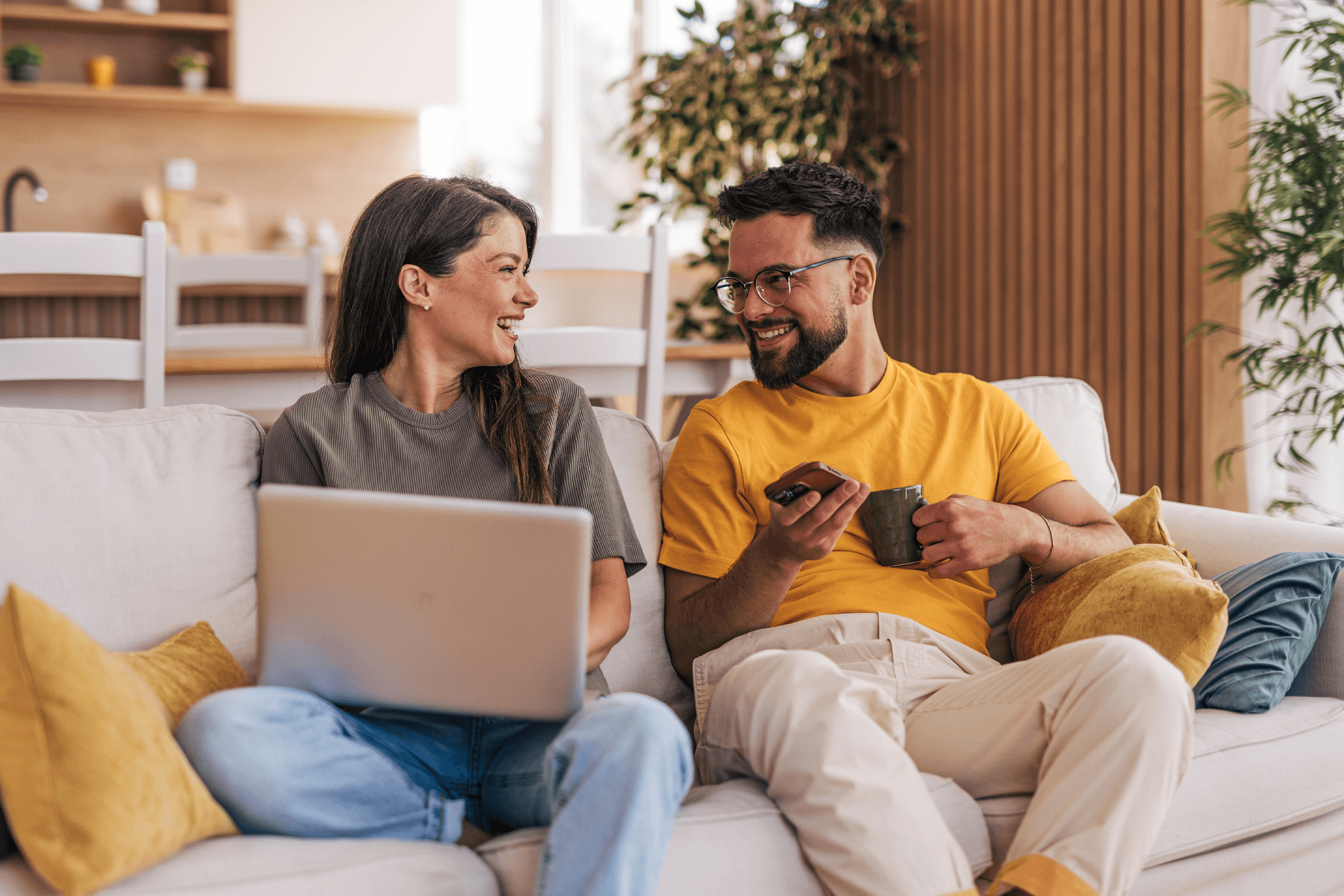 man and women on couch laughing